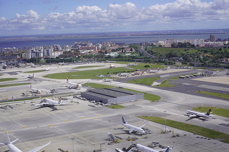 Aerial view of Lisbon Airport's apron with airliners parked and the city and river beyond